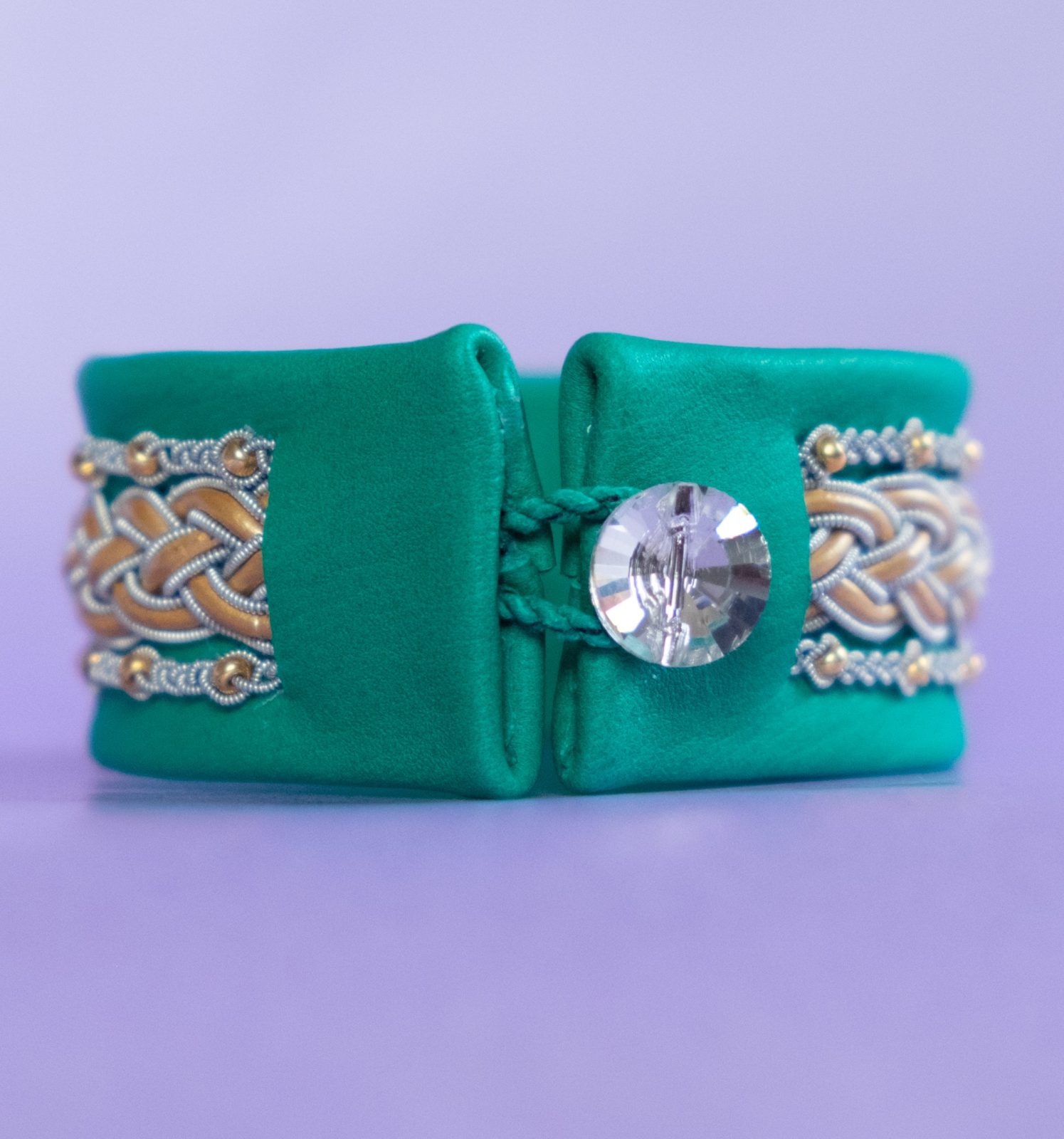 INGRID - Emerald green tin thread bracelet with gold-coloured leather details and seed beads. Swarovski-style glass button