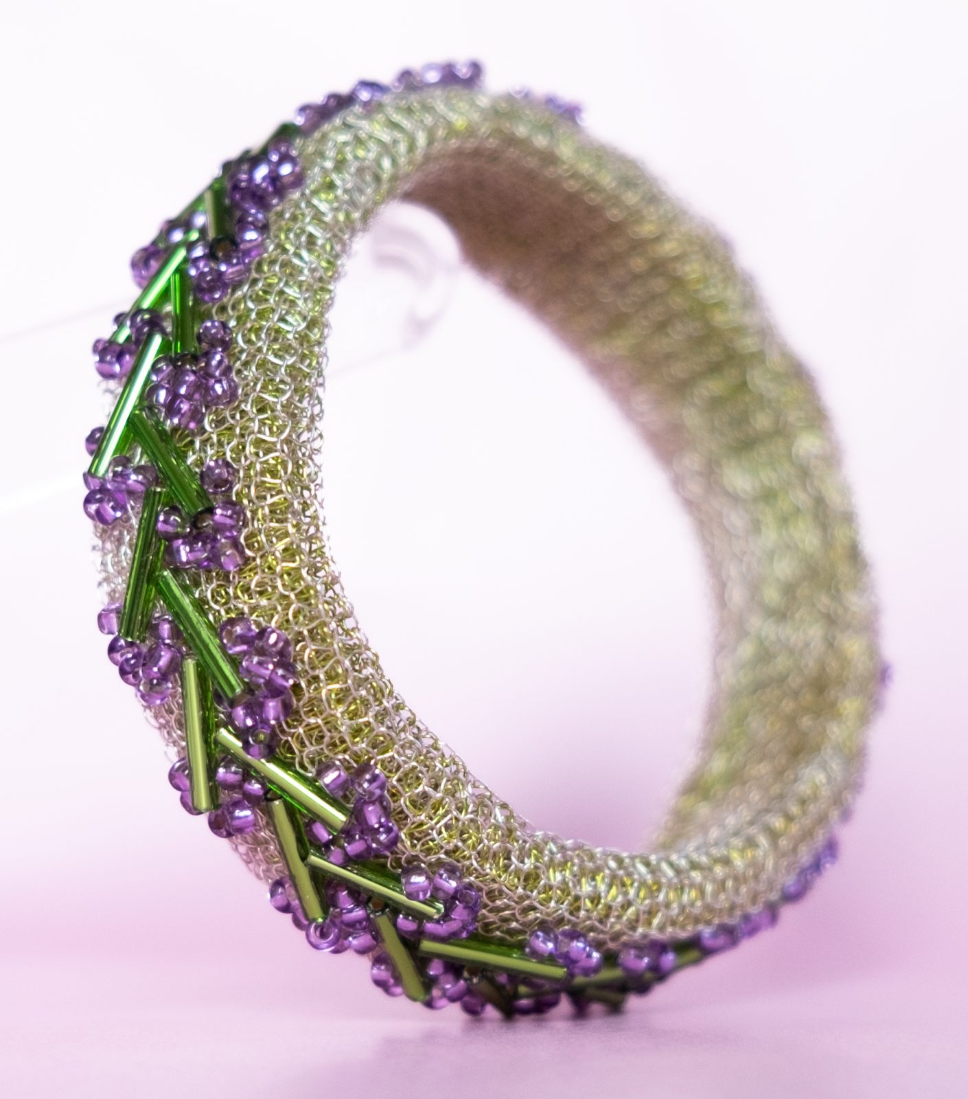 MAY - Armband - bangle - av stickad kopparwire med broderade lila och gröna glaspärlor
