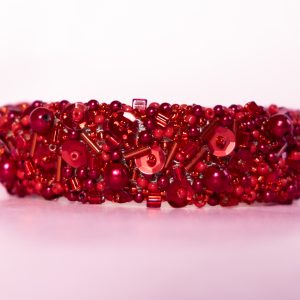 NORMA - Rött armband - bangle - av stickad wire med broderade pärlor och paljetter