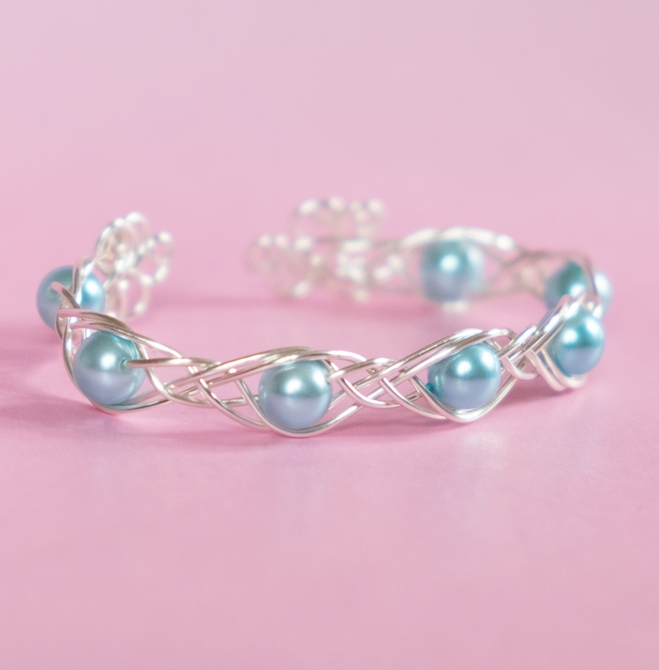 DEIRDRE – Armband av silverpläterad koppartråd med ljusblå glaspärlor – Keltisk fläta